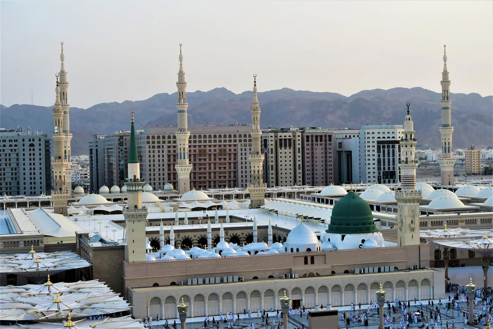 Al-Masjid an-Nabawi in Madinah, seen from above, with the city and the mountains behind